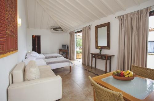 a living room with a couch and a table at Passeio das Palmeiras in Búzios