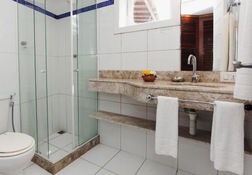 a bathroom with a glass shower and a toilet at Passeio das Palmeiras in Búzios