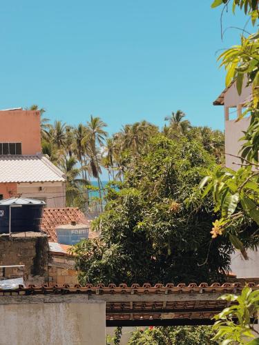 a tree on top of a building with palm trees in the background at Quarto vista mar in Prado