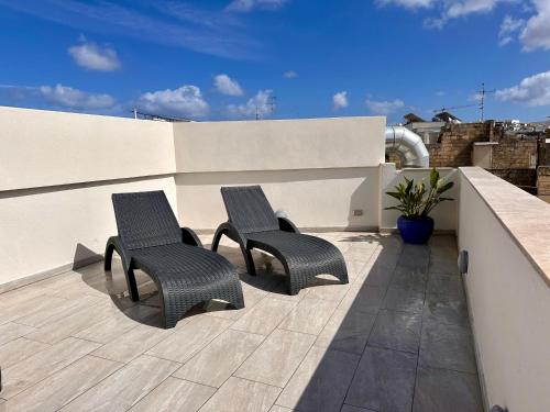 莫斯塔的住宿－Mosta Dome Penthouse，两把椅子坐在屋顶的庭院