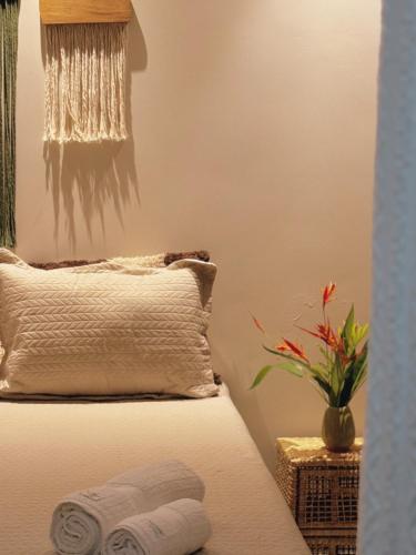 a bedroom with a bed with a pillow and a plant at Quarto vista mar in Prado