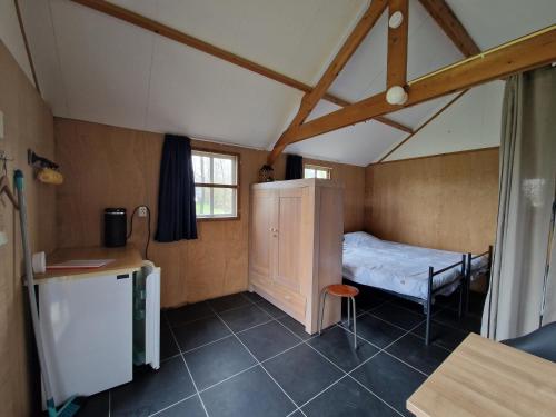 een kleine kamer met een klein bed in een huis bij Blokhut camping De Zilveren Maan in De Valom