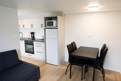 pequeña sala de estar con mesa y cocina en Eiðar - Apartments, en Eiðar