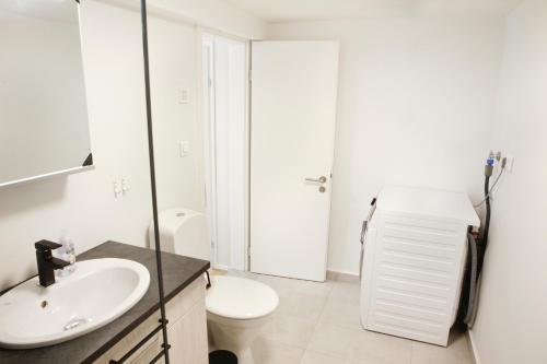 a bathroom with a sink and a toilet at Eiðar - Apartments in Eiðar
