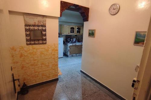 un couloir menant à une cuisine avec une horloge murale dans l'établissement Résidence Gharnata, à Marrakech
