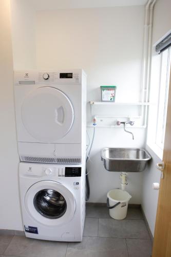 a washing machine in a bathroom with a sink at Eiðar - Apartments in Eiðar