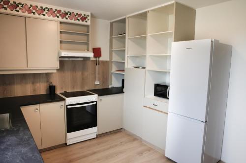 a kitchen with white appliances and a white refrigerator at Eiðar - Apartments in Eiðar