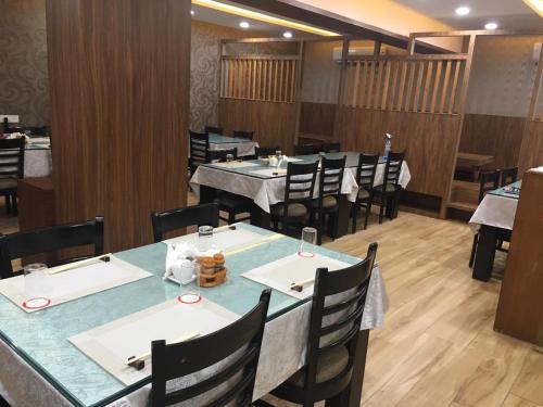 a dining room with tables and chairs in a restaurant at Le Tokyo Hotel Vithalapur in Vithalpur