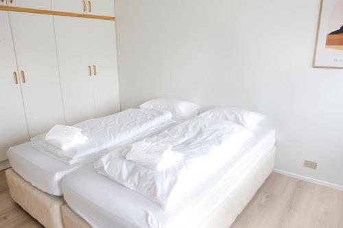 a white bed with white sheets and pillows at Eiðar - Apartments in Eiðar