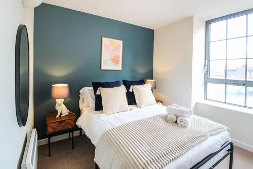 1 dormitorio con cama y pared azul en Modern 2 Bedroom Apartment by Train Station, en Nottingham