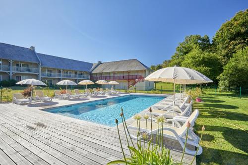 Saint Malo Golf Resort في Le Tronchet: مسبح مع كراسي الصالة والمظلات