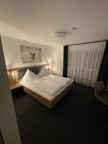 a bedroom with a large bed and a window at Pension Landgasthof Schützen in Tengen