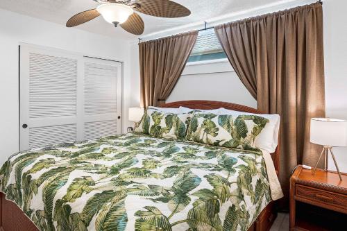 1 dormitorio con 1 cama con edredón verde y blanco en Kona Reef F23, en Kailua-Kona