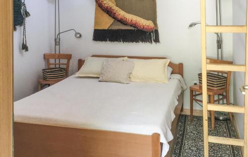 a bedroom with a bed with white sheets and a ladder at Beach Front Home In Gradac With House Sea View in Gradac