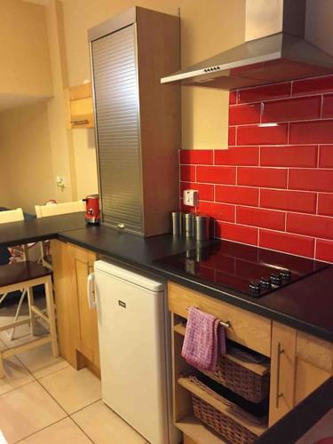 a kitchen with a black counter and a red wall at The Sardinian Guesthouse (6 Bedrooms) in Cobh