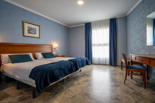 Habitación de hotel con cama, escritorio y escritorio. en Hotel Bartos en Almussafes