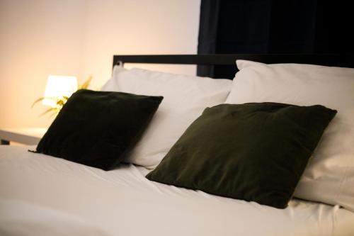 a bed with two black pillows on top of it at Whole Wide World Hostel in Zagreb