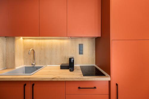 une cuisine avec des armoires orange et un évier dans l'établissement The 8 Suites, à Polychrono