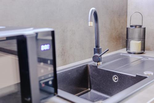 a kitchen counter with a sink and a microwave at Rezidence Petra Voka in Třeboň