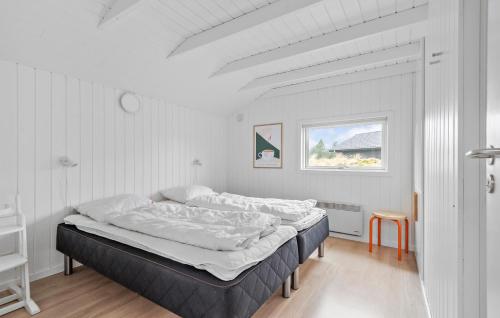 um quarto com uma cama num quarto branco em Beautiful Home In Blvand With Sauna em Blåvand