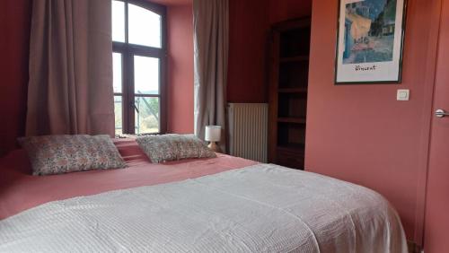 a bedroom with a bed with pink walls and a window at B&B Ferme1883 in Lierneux