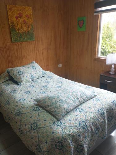1 dormitorio con cama con almohada y ventana en Las Bandurrias, en La Chamiza