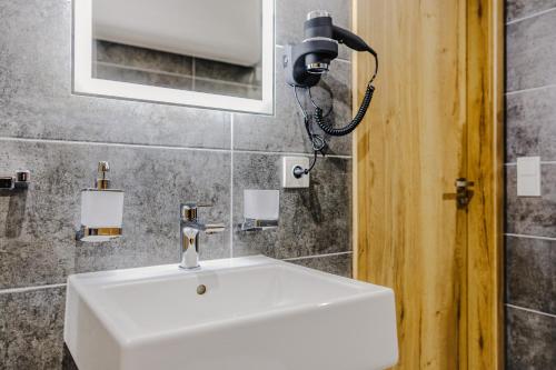 a bathroom with a white sink and a mirror at Rezidence Petra Voka in Třeboň