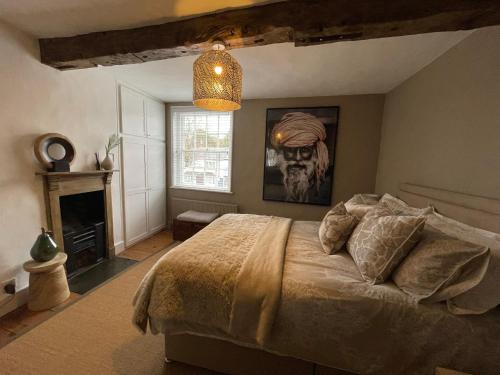 ein Schlafzimmer mit einem großen Bett und einem Kronleuchter in der Unterkunft 3-storey luxury Georgian house, High St, Henley-in-Arden in Henley in Arden