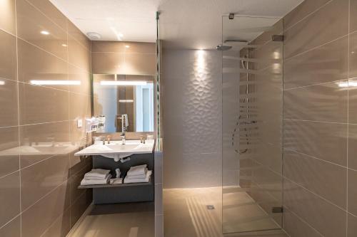 a bathroom with a sink and a shower at Saint Malo Golf Resort in Le Tronchet