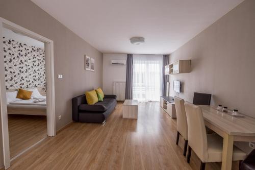 ein Wohnzimmer mit einem Sofa und einem Tisch in der Unterkunft Maple Tree Budget Apartments in Budapest