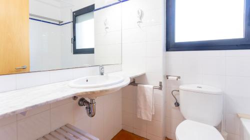 a white bathroom with a sink and a toilet at CANADELL BLOC B baixos 1ª in Calella de Palafrugell