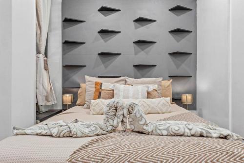 a bedroom with a large bed with a wall with black triangles at Luxury Two Bedroom Flat right opposite to Harrods KB15 in London