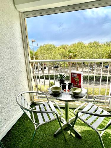 - un balcon avec une table et deux chaises dans l'établissement Cap d'Agde Port - La Falaise, au Cap d'Agde