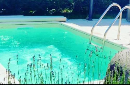 una piscina con acqua blu in un cortile di Gîte de Juliana 6 personnes a Sundhouse