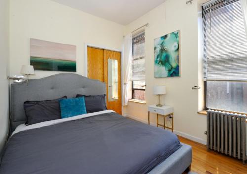 een slaapkamer met een groot bed en 2 ramen bij Modern 2 Bed One Bath At West Side in New York