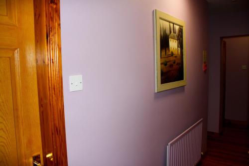 a hallway with a white wall with a picture on it at The Coach Inn in Strabane