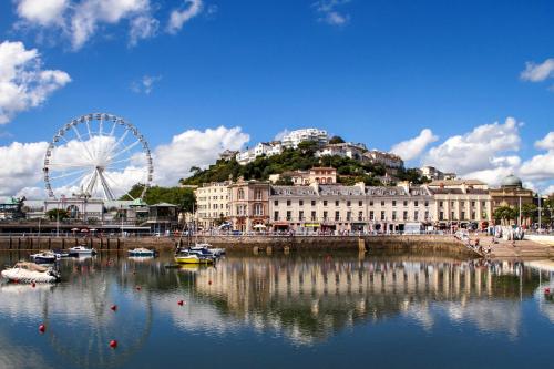 Beautiful Caravan With Decking At Hoburne Devon Bay, Ref 54058f في بينتون: عجل فيريس ومبنى مع عجل فيريس