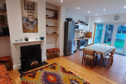 uma sala de estar com uma mesa e um frigorífico em Stylish Victorian House em Watford