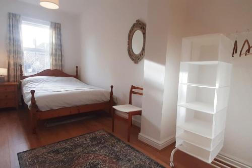 a bedroom with a bed and a mirror on the wall at Stylish Victorian House in Watford
