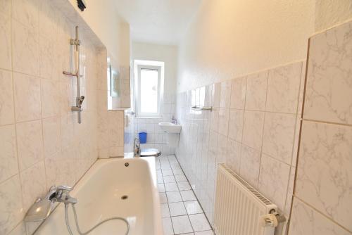 un bagno bianco con vasca e lavandino di CoreRooms - Apartment Bochum Wattenscheid a Bochum