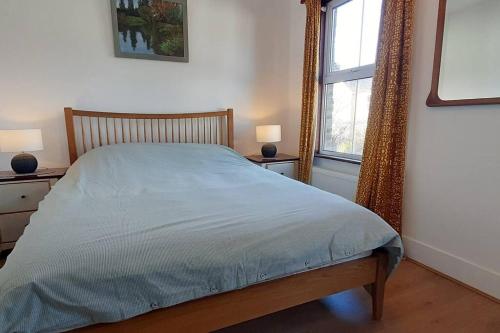 Un dormitorio con una cama y dos ventanas en Stylish Victorian House, en Watford