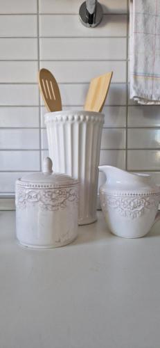 a counter with two white dishes and a bowl and utensils at CENTRUM with private parking in Virovitica