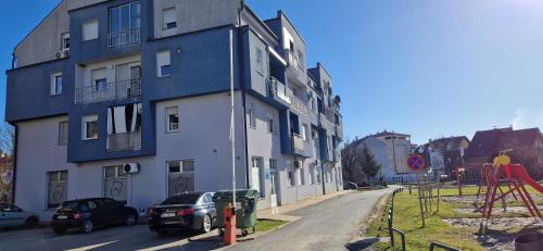a blue and white building with a car parked next to it at CENTRUM with private parking in Virovitica