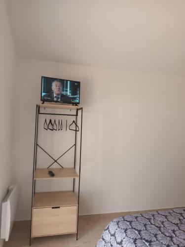 a television sitting on a stand in a bedroom at Petite Maison dans le Gers 32 in Mouchan