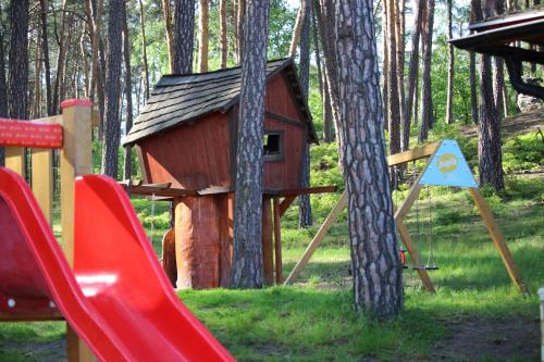 a playground with a bird house and a slide at Remote Work Friendly Zahradní apartmán u jezera in Staré Splavy