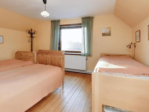 1 dormitorio con 2 camas y ventana en Holiday home Læsø II, en Læsø