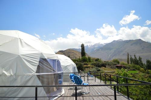 a couple of tents on a deck with mountains at SG Glamping Resort in Hunza Valley
