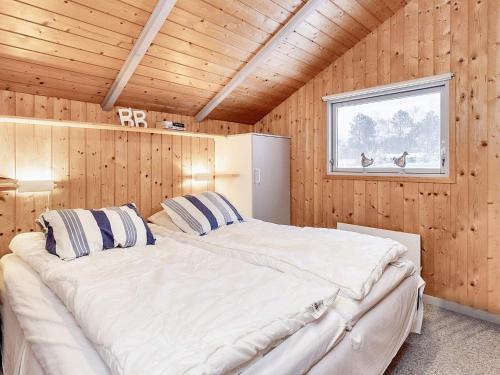 a bedroom with two beds in a wooden cabin at 6 person holiday home in Ålbæk-By Traum in Ålbæk