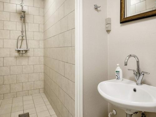 y baño blanco con lavabo y ducha. en Holiday home Bogense XLVII, en Bogense
