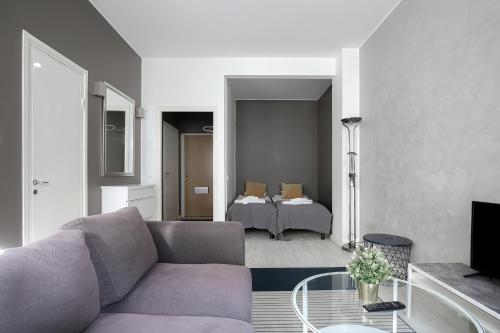 een woonkamer met een bank en een bed bij Kotimaailma Apartments Kamppi - studio for 2 in Helsinki
